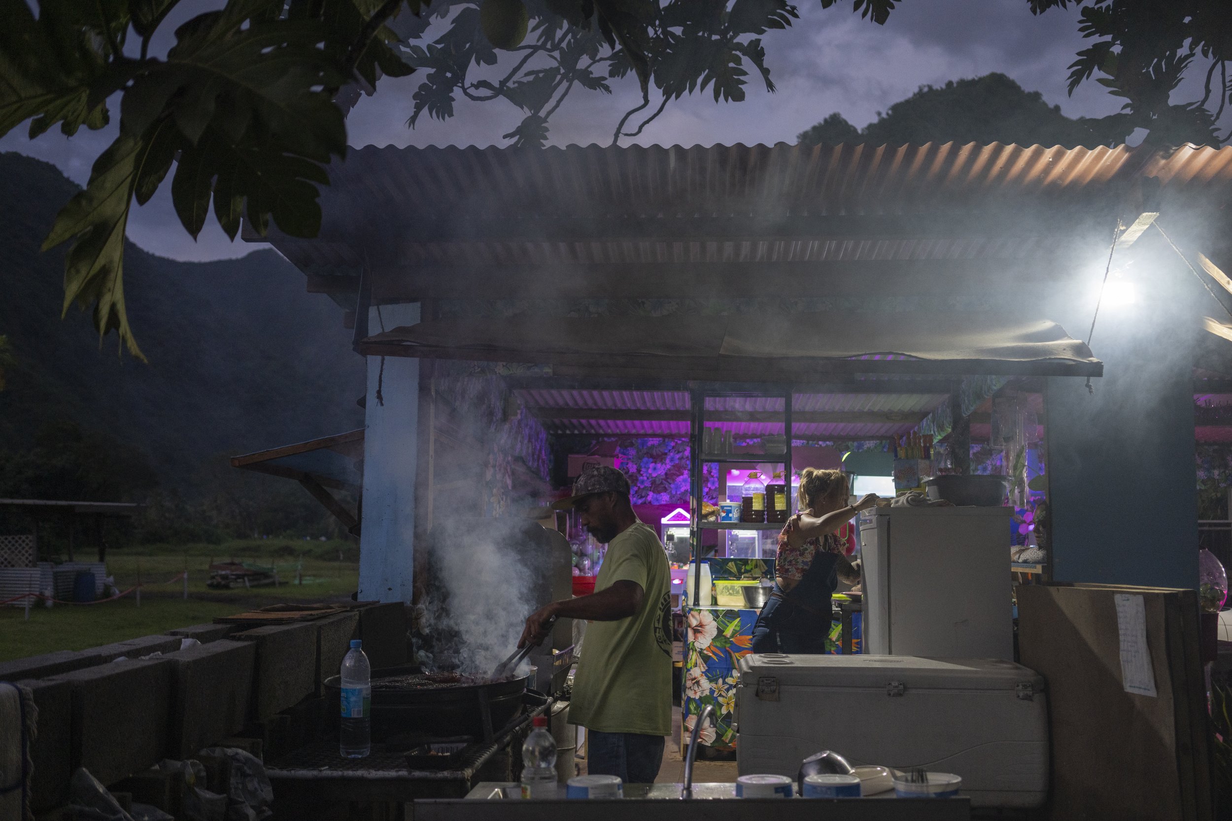  A man tends to a barbecue at a snack bar in Teahupo'o, Tahiti, French Polynesia, Tuesday, Jan. 16, 2024. (AP Photo/Daniel Cole)    