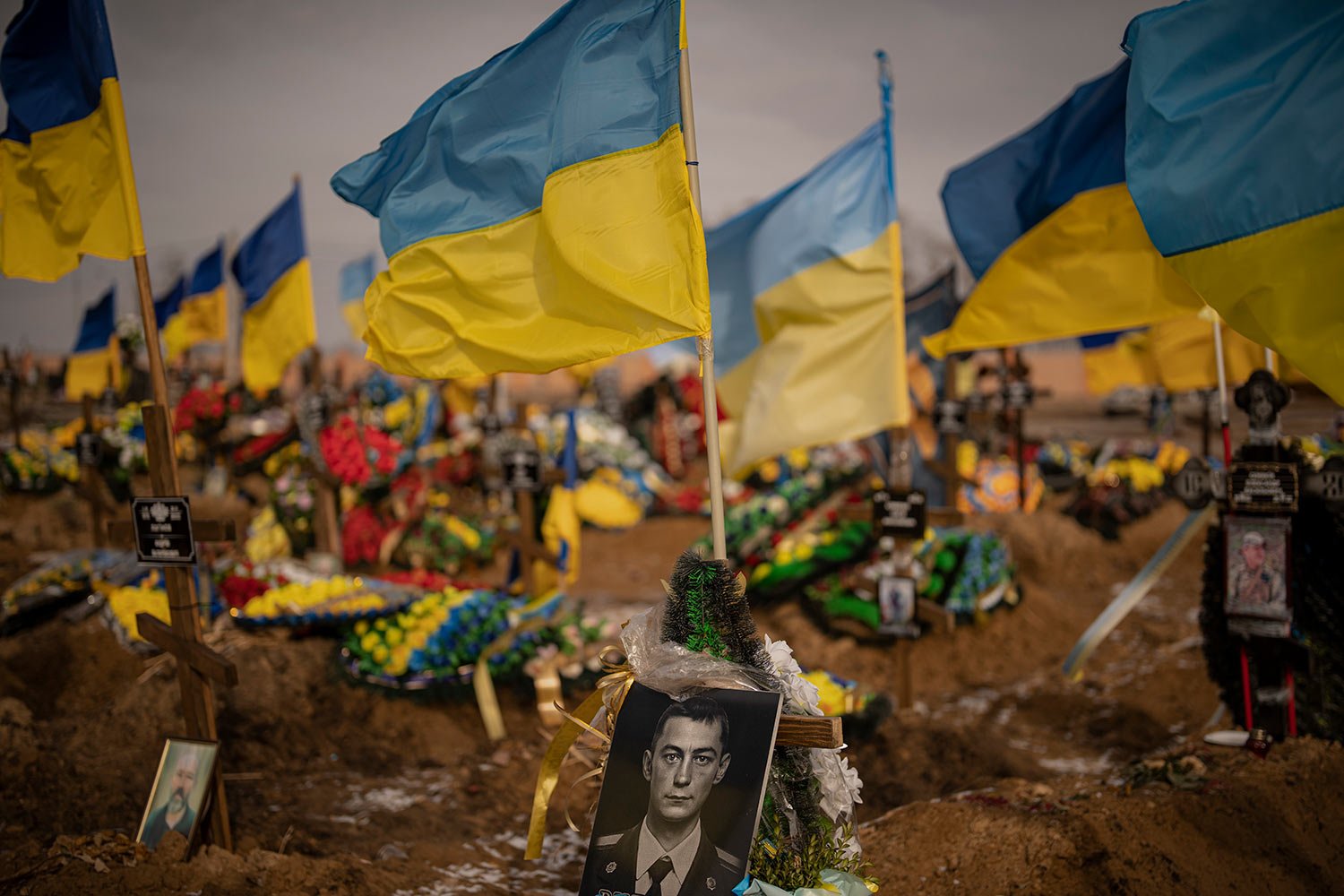  A photograph of a Ukrainian serviceman is placed on his grave in the Alley of Glory section of the cemetery in Kharkiv, Ukraine, Friday, Feb. 24, 2023. (AP Photo/Vadim Ghirda) 