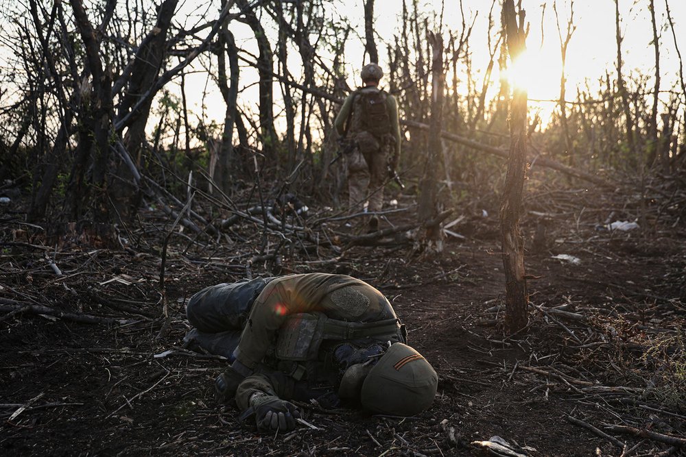  A Ukrainian assault unit commander passes by a dead Russian soldier on the front line near Andriivka, Ukraine, Saturday, Sept. 16, 2023. (AP Photo/Alex Babenko) 