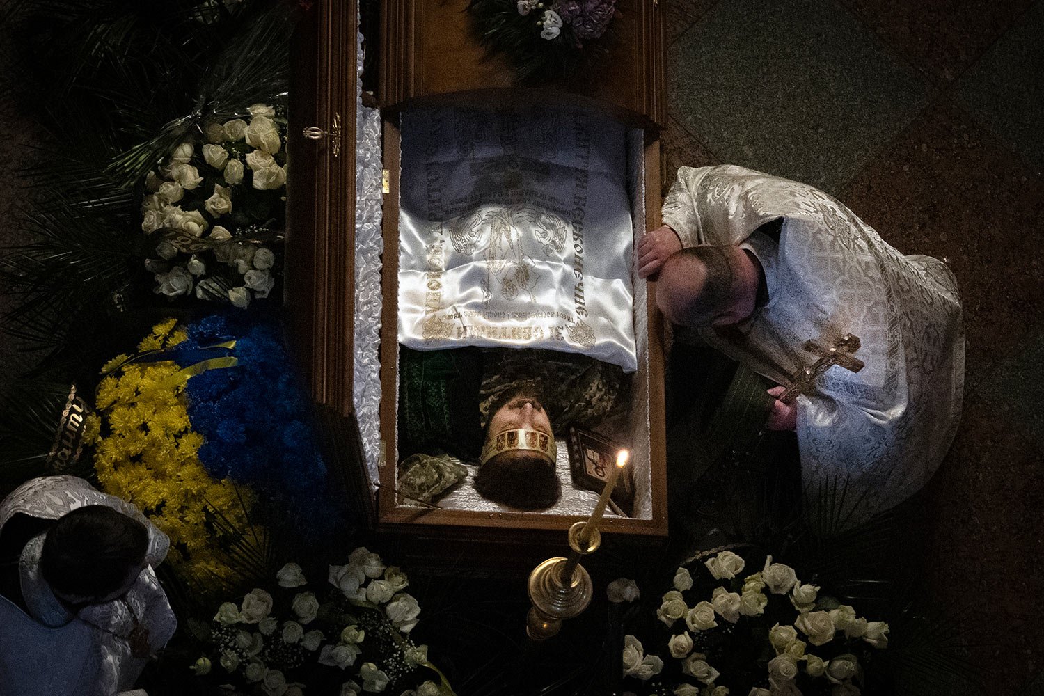  A priest pays his respects during the funeral of Ukrainian serviceman and famous poet Maksym Kryvtsov in St. Michael Cathedral in Kyiv, Ukraine, Thursday, Jan. 11, 2024. (AP Photo/Efrem Lukatsky) 