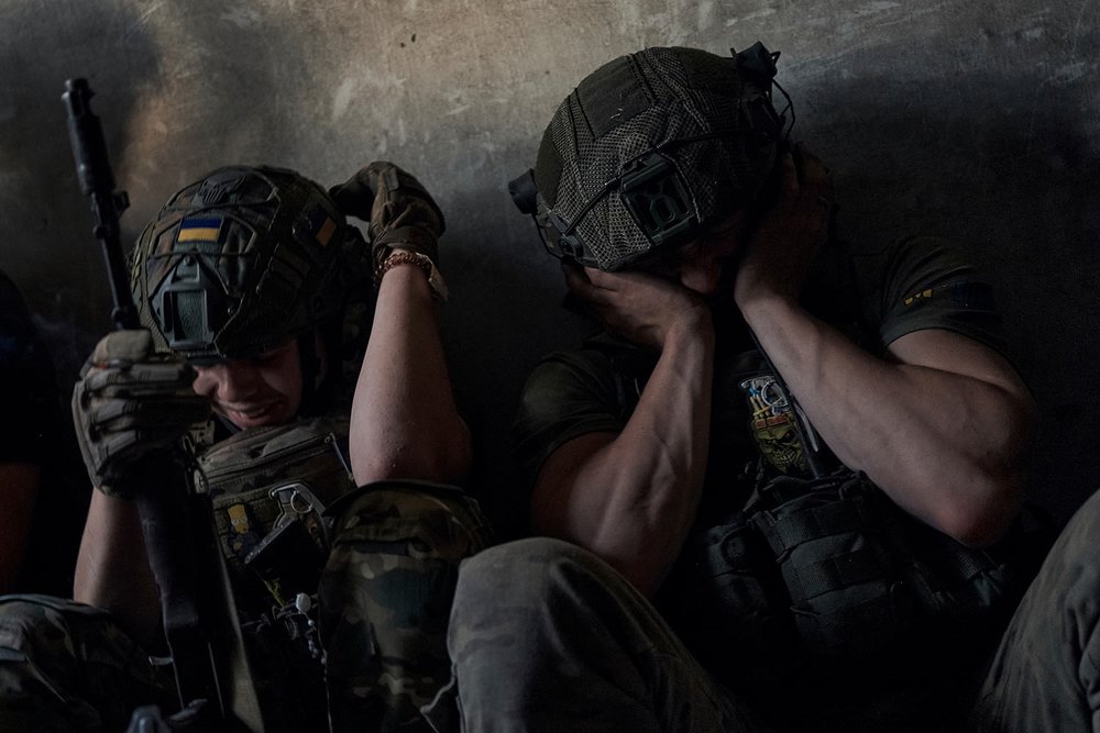  Ukrainian soldiers cover their ears to protect them from the sound of Russian shelling in a shelter on the front line in the Zaporizhzhia region, Ukraine, Sunday, July 2, 2023. (AP Photo/Libkos) 