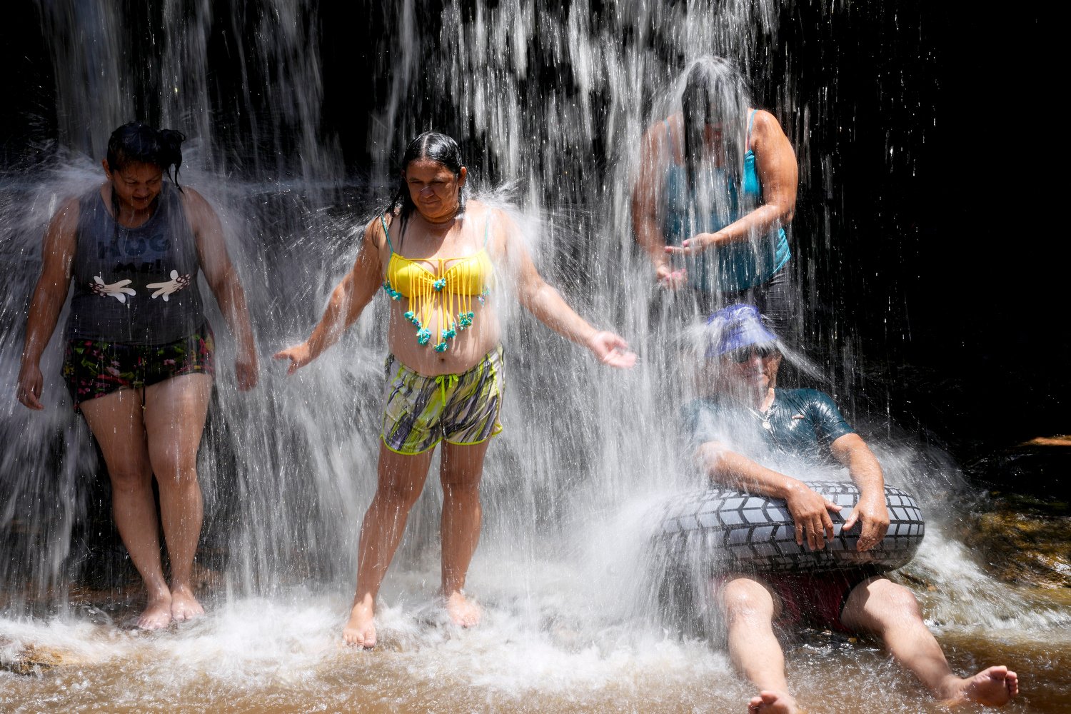  People cool off in a stream on a hot summer day in Piribebuy, Paraguay, Sunday, Feb. 11, 2024. (AP Photo/Jorge Saenz) 