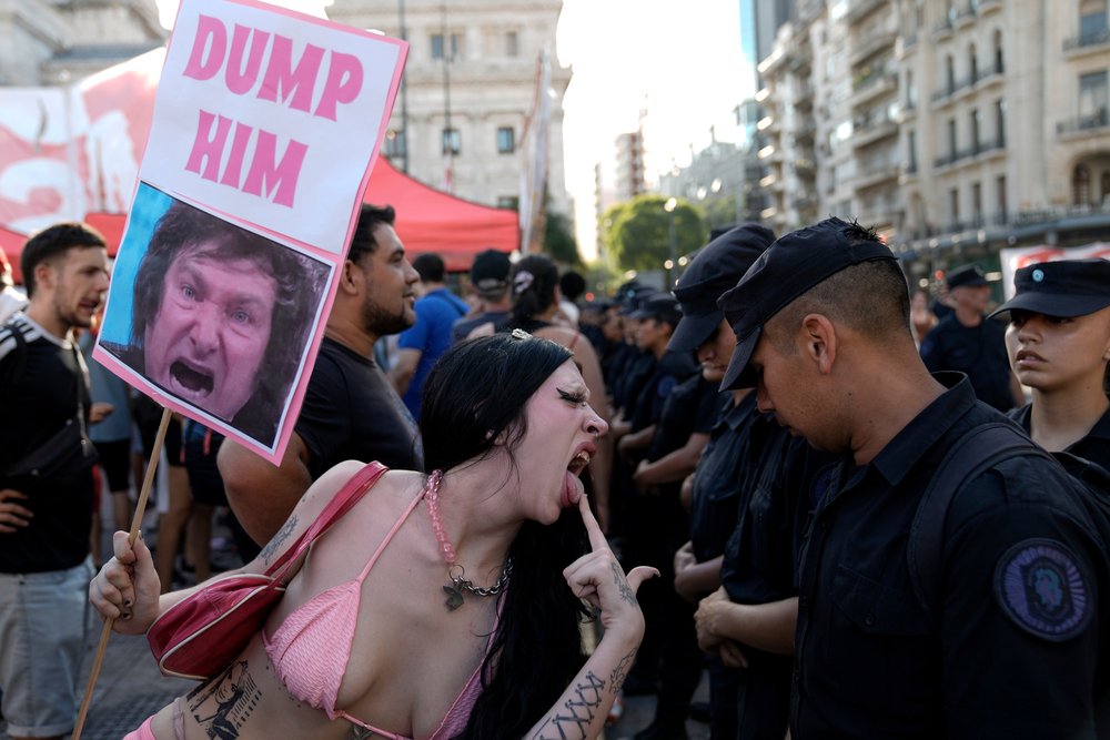  An anti-government protester jeers at police guarding Congress where lawmakers are debating a bill promoted by Argentine President Javier Milei in Buenos Aires, Argentina, Thursday, Feb. 1, 2024. The bill includes a broad range of economic, administ