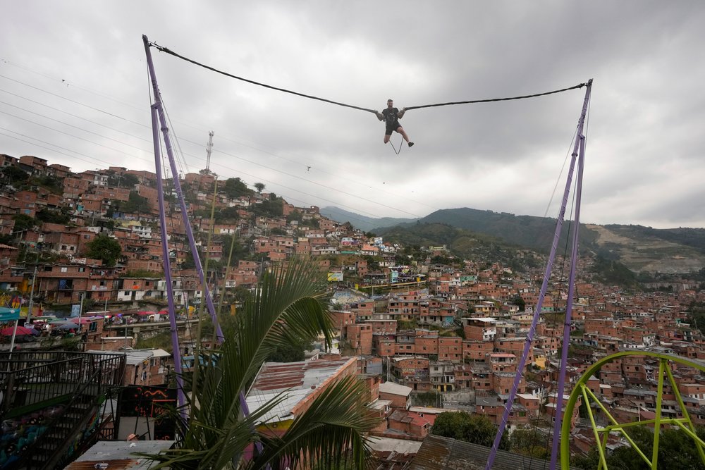  A tourist rides a bungee jump in the Comuna 13 neighborhood of Medellin, Colombia, Friday, Feb. 2, 2024. Once a battleground for fighting among drug cartels, leftist guerrillas, military forces, and government-linked paramilitary groups, the area is