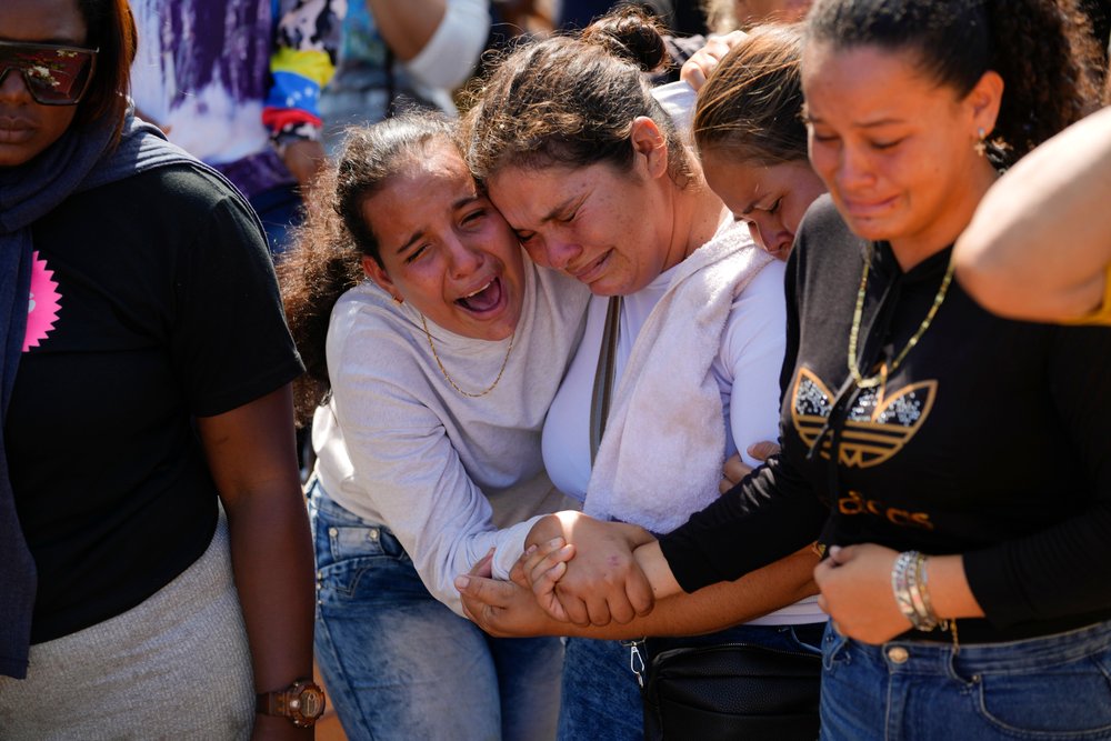  A sister of miner Santiago Mora, left, cries with other relatives as he is buried at the cemetery in La Paragua, Bolivar state, Venezuela, Thursday, Feb. 22, 2024. The collapse of an illegally operated open-pit gold mine in central Venezuela killed 