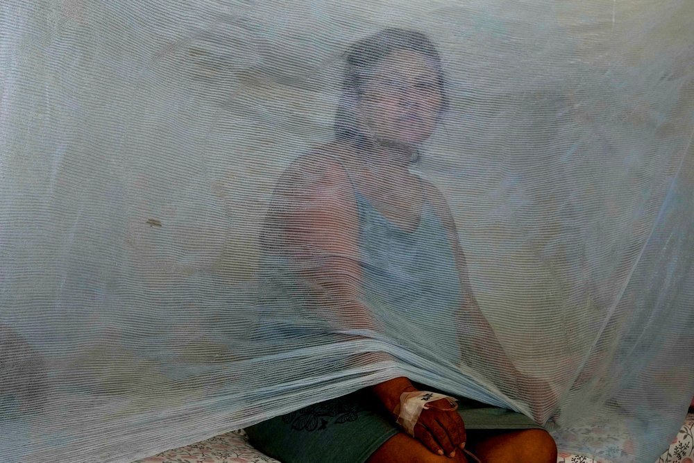  Jenny Chiroque, who suffers from dengue, sits behind netting at La Merced Hospital in Paita, Peru, Thursday, Feb. 29, 2024. Peru declared a health emergency in most of its provinces due to a growing number of dengue cases. (AP Photo/Martin Mejia) 
