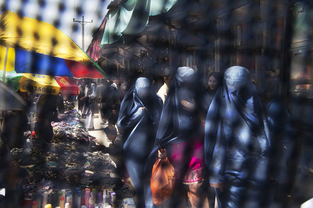   Seen through the eye grid of a burqa, women walk through a market in Kabul, Afghanistan on Thursday, April 11, 2013. (AP Photo/Anja Niedringhaus) 