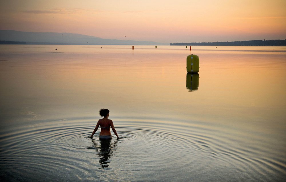   A woman takes a dip in Lake Geneva at sunrise in Geneva, Switzerland on Sunday, July 21, 2013. (AP Photo/Anja Niedringhaus) 