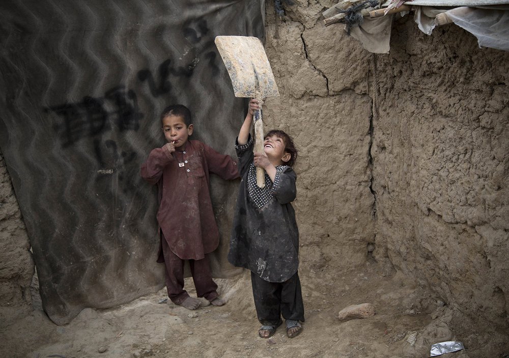  A young Afghan girl plays with a broken shovel outside her makeshift house at a refugee camp in Kabul, Afghanistan, Friday, May 10, 2013. (AP Photo/Anja Niedringhaus) 