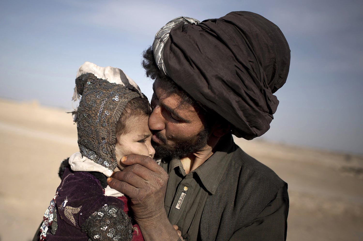  A nomad kisses his young daughter while watching his herd in Marjah, Helmand province, Afghanistan on Oct. 20, 2012. (AP Photo/Anja Niedringhaus) 
