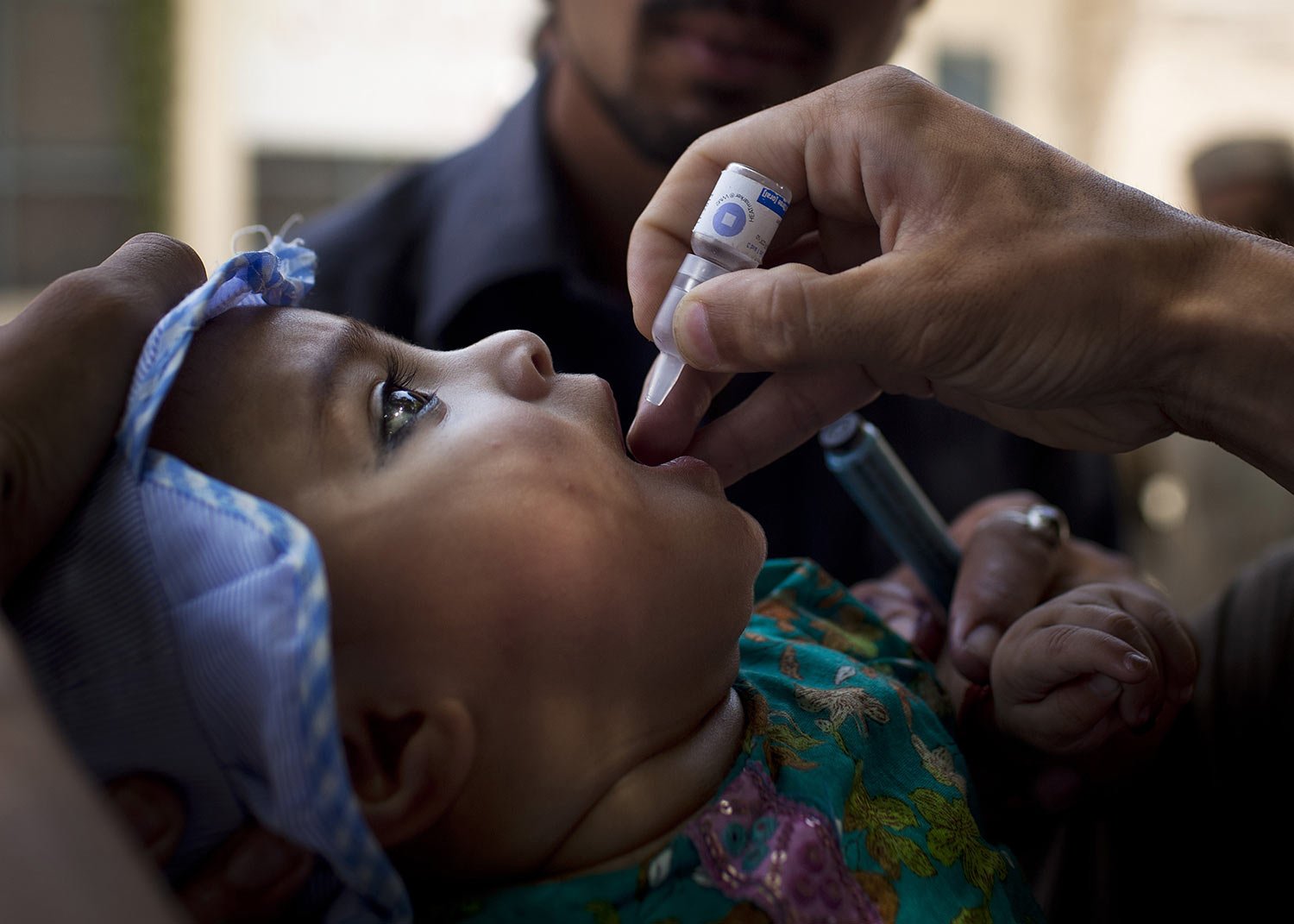  A child is administered a polio vaccination by a district health team worker outside a children's hospital in Peshawar, Pakistan on Wednesday, May 30, 2012. (AP Photo/Anja Niedringhaus) 