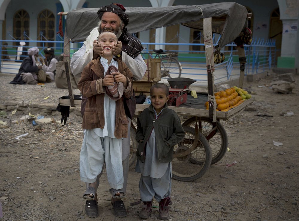  A fruit seller lifts his son by his cheeks in the center of Kandahar, Afghanistan, Wednesday, March 12, 2014. (AP Photo/Anja Niedringhaus) 