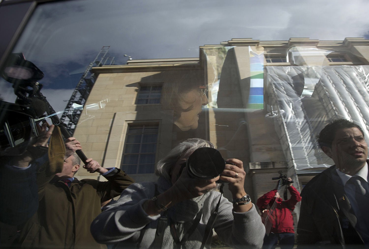  Journalists, including Associated Press photographer Anja Niedringhaus, reflected in the window at lower center, surround the car of Bouthaina Shaaban, advisor to Syrian President Assad, as she leaves after meeting with the Syrian opposition at the 
