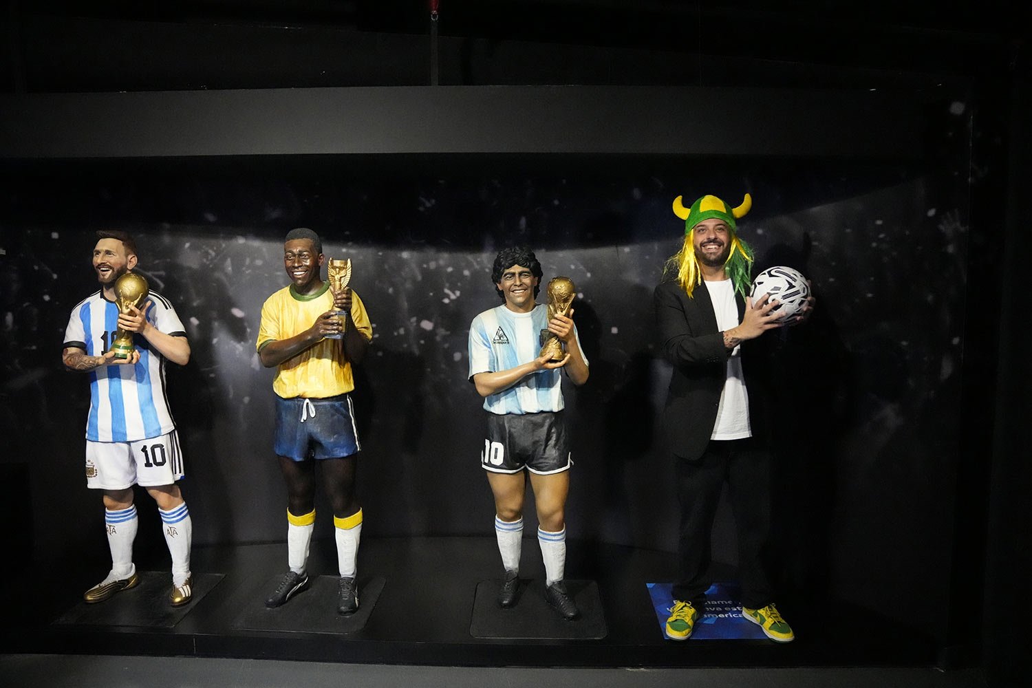  A Brazil soccer fan poses next to life-size statues of South American soccer stars, from left, Lionel Messi, Pele and Diego Maradona at the CONMEBOL museum on the day of its re-inauguration in Luque, Paraguay, March 18, 2024. (AP Photo/Jorge Saenz) 