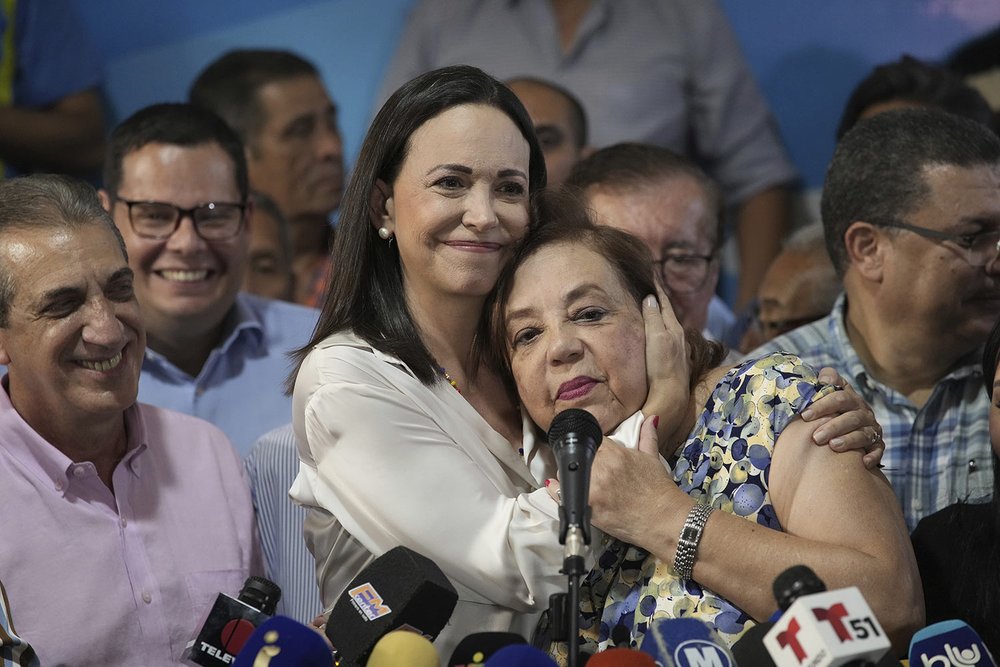  Opposition leader María Corina Machado embraces Corina Yoris during a press conference in Caracas, Venezuela, March 22, 2024. Machado named Yoris as a substitute to her presidential bid while she fights a government ban on her running for office. (A