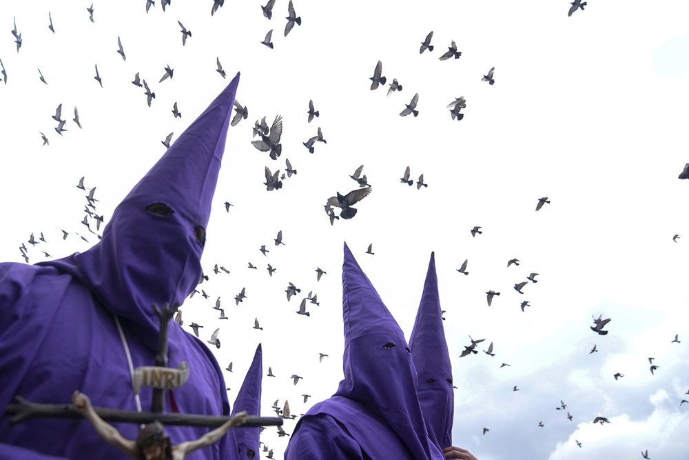  Birds fly over penitents known as cucuruchos during the Jesus the Almighty Good Friday procession, as part of Holy Week celebrations, in Quito, Ecuador, March 29, 2024. (AP Photo/Dolores Ochoa) 