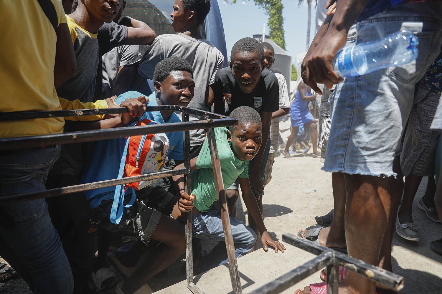  Youth take cover after hearing gunshots at a public school that serves as a shelter for people displaced by gang violence, in Port-au-Prince, Haiti, March 22, 2024. (AP Photo/Odelyn Joseph) 