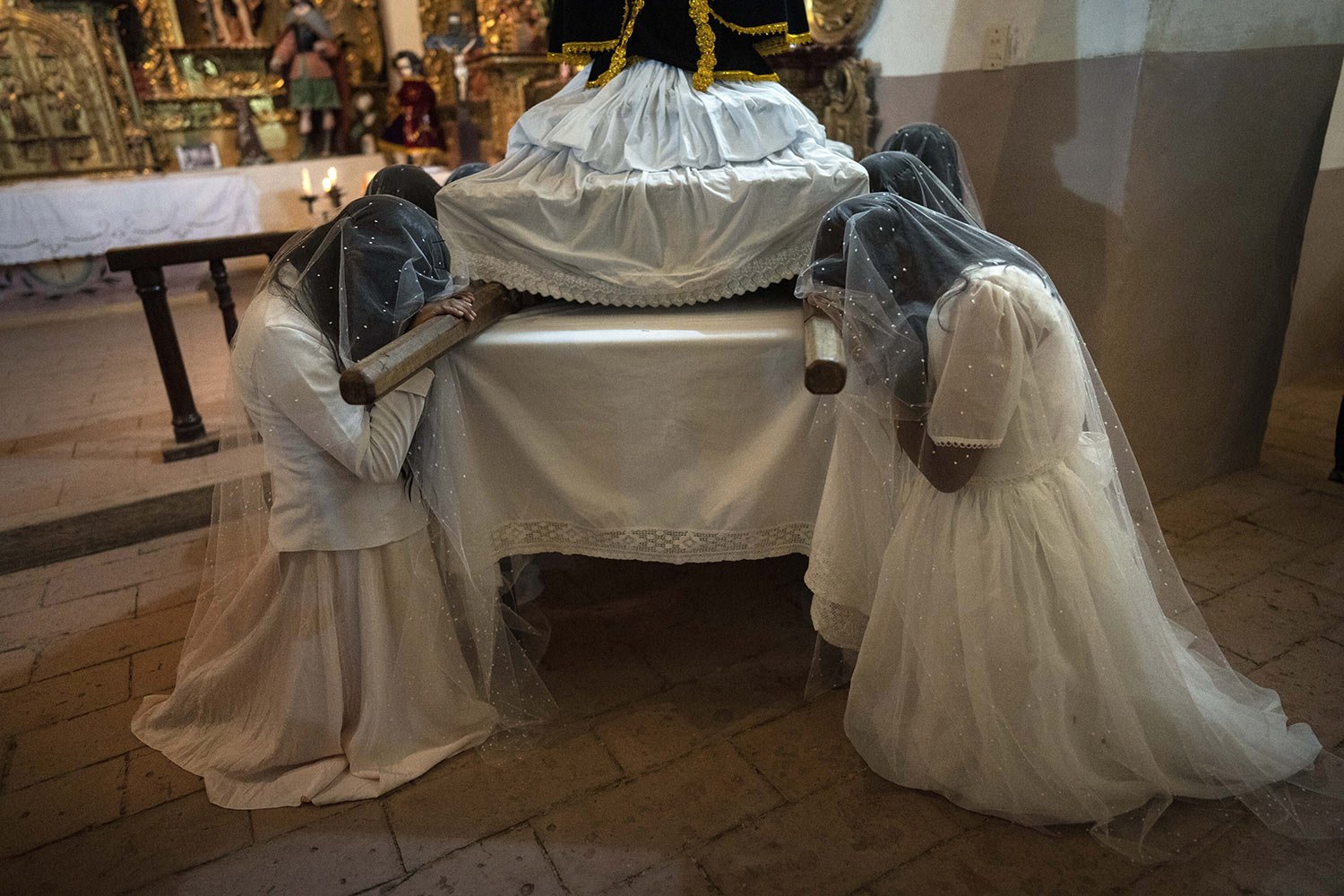  'Piadosas' or pious ones pray over a statue of the Virgin Mary during the 'Lloronas' or Weeping Women’s procession as part of Good Friday in Yavi, Argentina, March 29, 2024. (AP Photo/Rodrigo Abd) 