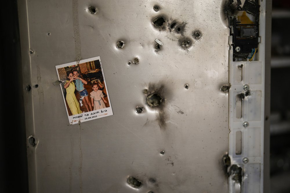  A photo hangs on a refrigerator riddled with bullet holes in a house at Kibbutz Kissufim in southern Israel, Saturday, Oct. 21, 2023. Photo by Francisco Seco 