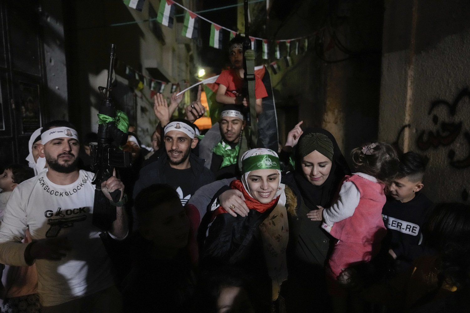  Aseel al-Titi, wearing a Hamas headband, a former Palestinian prisoner who was released by the Israeli authorities, is greeted by friends and family members in Balata, a Palestinian refugee camp in Nablus, West Bank, Friday, Nov. 24, 2023.  Photo by