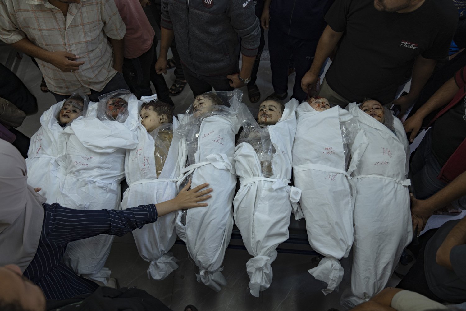  Palestinians stand around the bodies of children killed in Israeli bombardment of the Gaza Strip in a morgue in Khan Younis, Thursday, Oct. 19, 2023. Photo by Fatima Shbair 