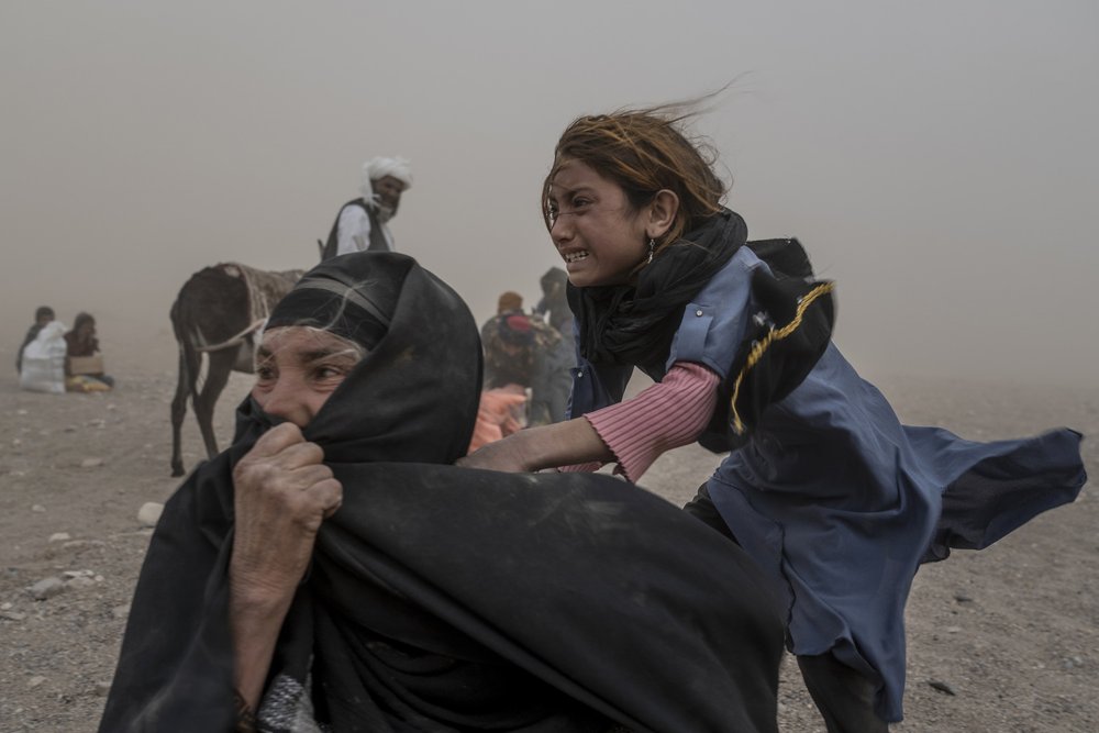  An Afghan girl and woman receive aid, while they are scared and crying from the fierce sandstorm, after an earthquake in Zenda Jan district in Herat province, western of Afghanistan, Thursday, Oct. 12, 2023. Another strong earthquake shook western A