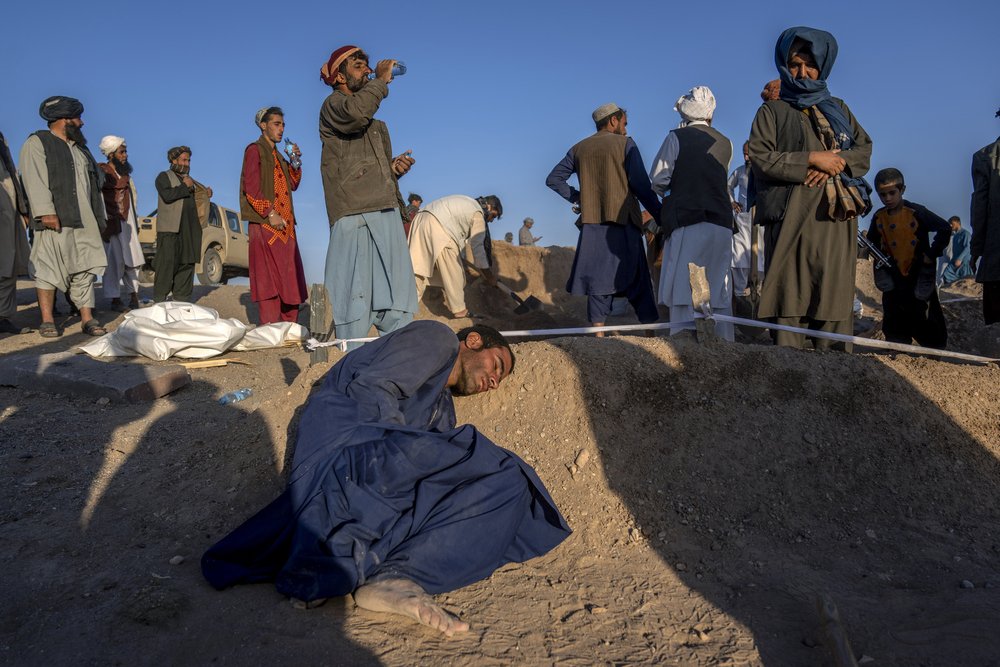  An Afghan man rests his head on the grave of his wife who died due to an earthquake and talks to her at a burial site, in Zenda Jan district in Herat province, western of Afghanistan, Monday, Oct. 9, 2023. Saturday's deadly earthquake killed and inj