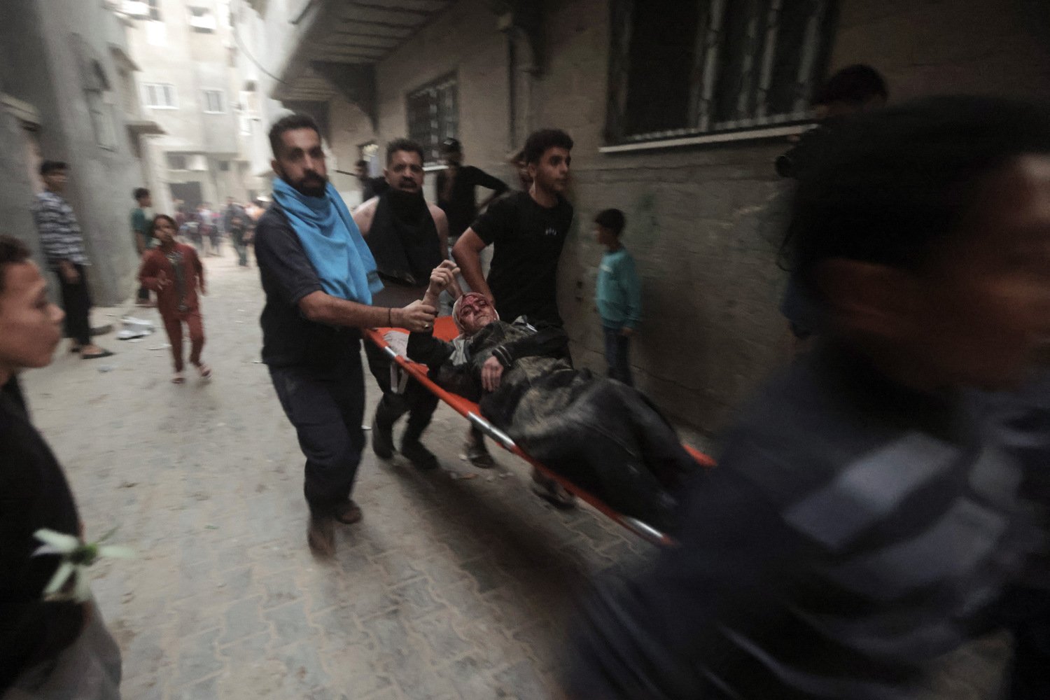  Palestinians evacuate a wounded woman following an Israeli airstrike in Khan Younis refugee camp, southern Gaza Strip, Monday, Nov. 13, 2023.  