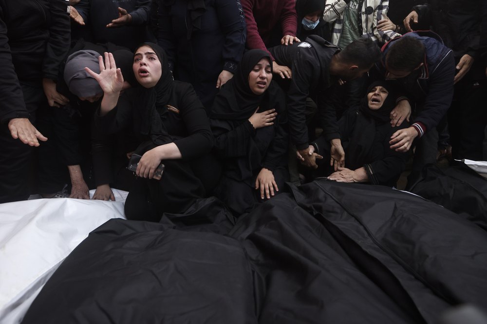 Palestinians mourn relatives killed in the Israeli bombardment of the Gaza Strip outside a morgue in Khan Younis on Wednesday, Dec. 20, 2023.  