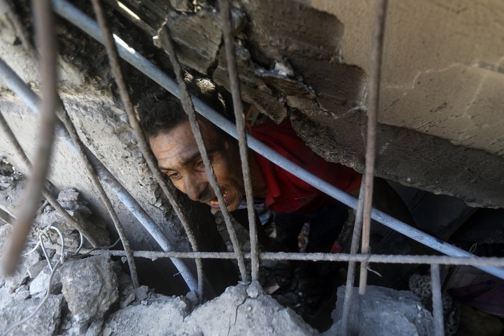  Palestinians look for survivors under the rubble of a destroyed building following an Israeli airstrike in Khan Younis refugee camp, southern Gaza Strip, Monday, Nov. 6, 2023.  