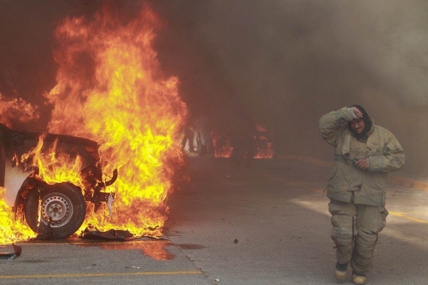  A truck burns after it was set fire by students protesting the previous month's shooting of one of their classmates during a confrontation with police, as firefighters work to control the blazes outside the municipal government palace in Chilpancing