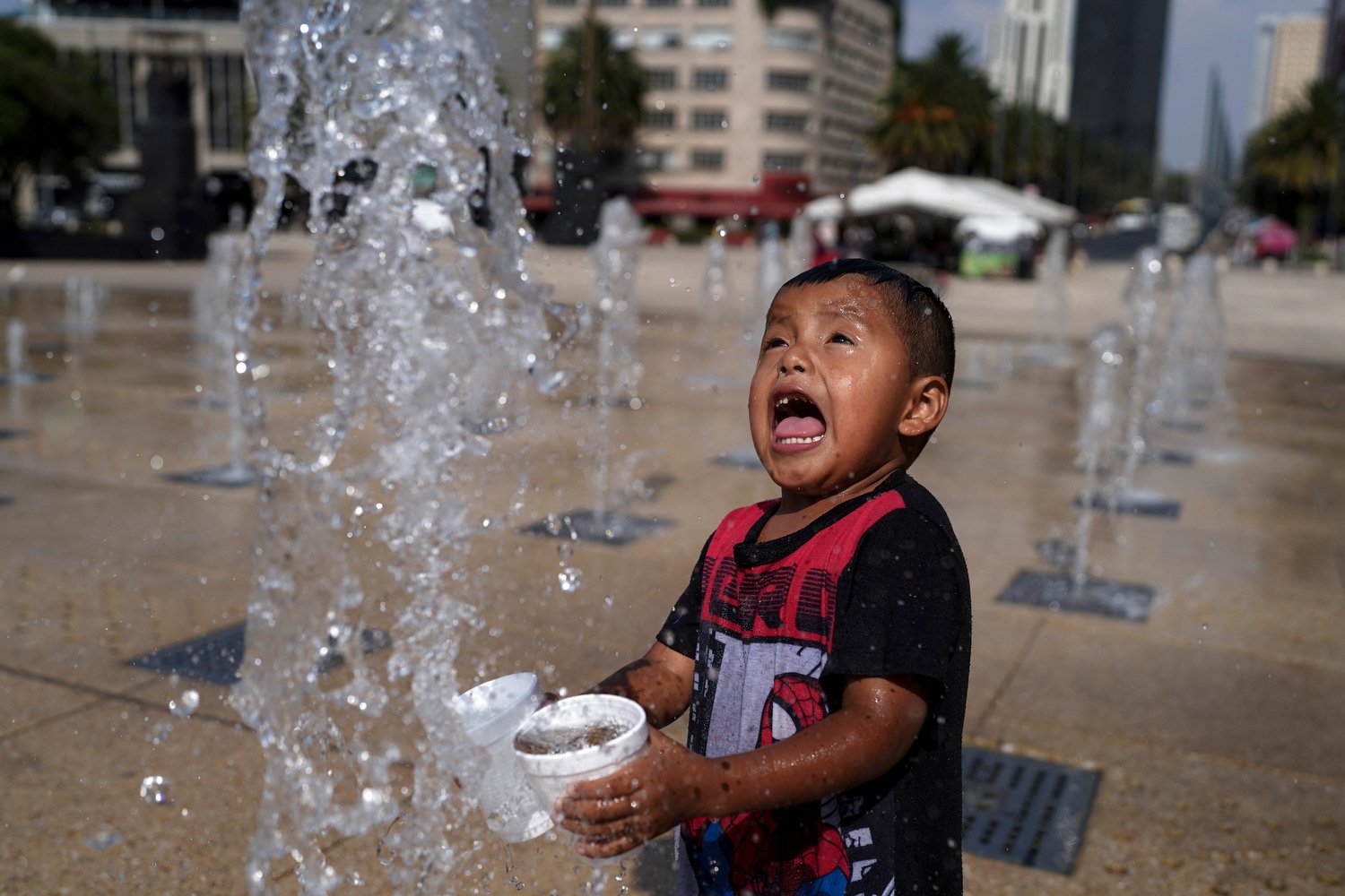  A child squeals with laughter while playing in the water fountain at the base of the Monument to the Revolution, amid high temperatures in Mexico City, April 16, 2024.  Mexican officials said El Niño and heat waves have caused the recent falloff in 