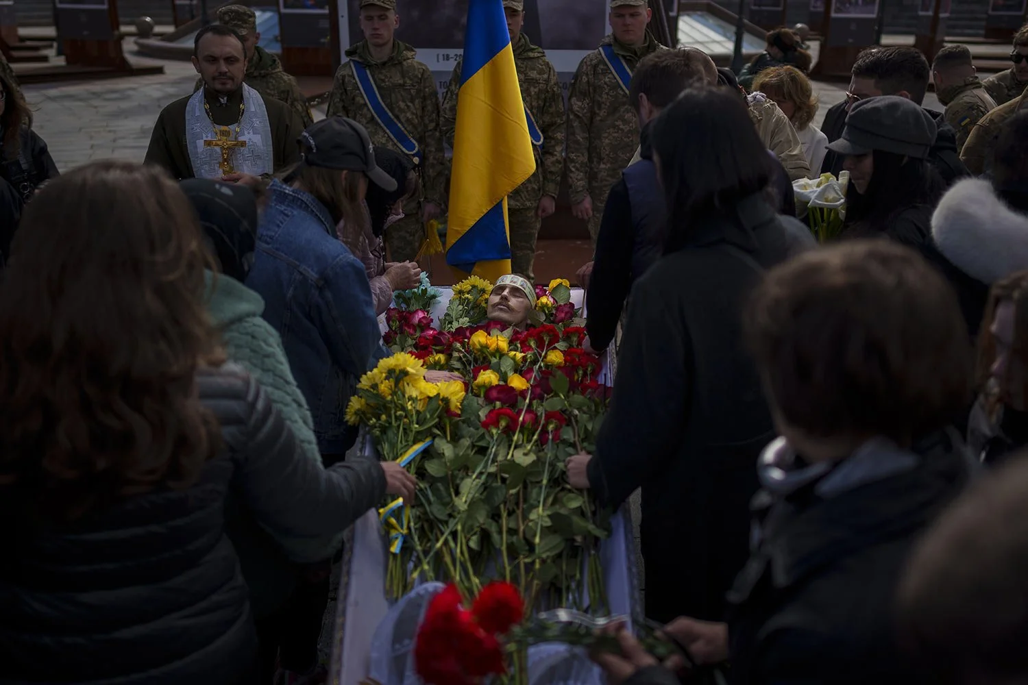  People bid farewell and lay flowers in the coffin of fallen Ukrainian serviceman Vadym Popelniuk, born in 1991, during a religious service in Independence Square in Kyiv, Ukraine, Friday, April 5, 2024. (AP Photo/Vadim Ghirda) 