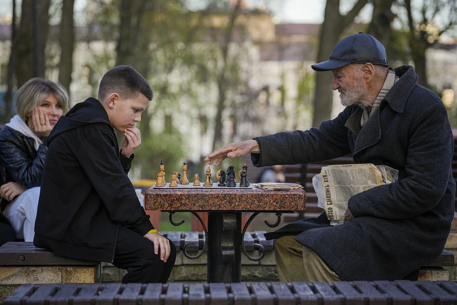  An elderly man plays chess with a boy training him to perfect his game in Taras Shevchenko Park, in Kyiv Ukraine, Sunday, April 7, 2024. (AP Photo/Vadim Ghirda) 