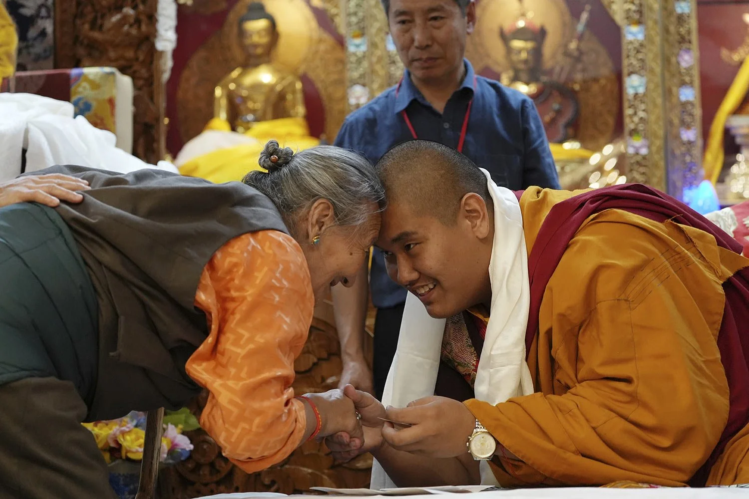 U.S.-born Buddhist lama, Jalue Dorje, right, and a member of the Minnesota Tibetan community bow and touch foreheads in a traditional Tibetan greeting at his 18th birthday and enthronement ceremony in Isanti, Minn., on Saturday, Nov. 9, 2024. (AP Ph