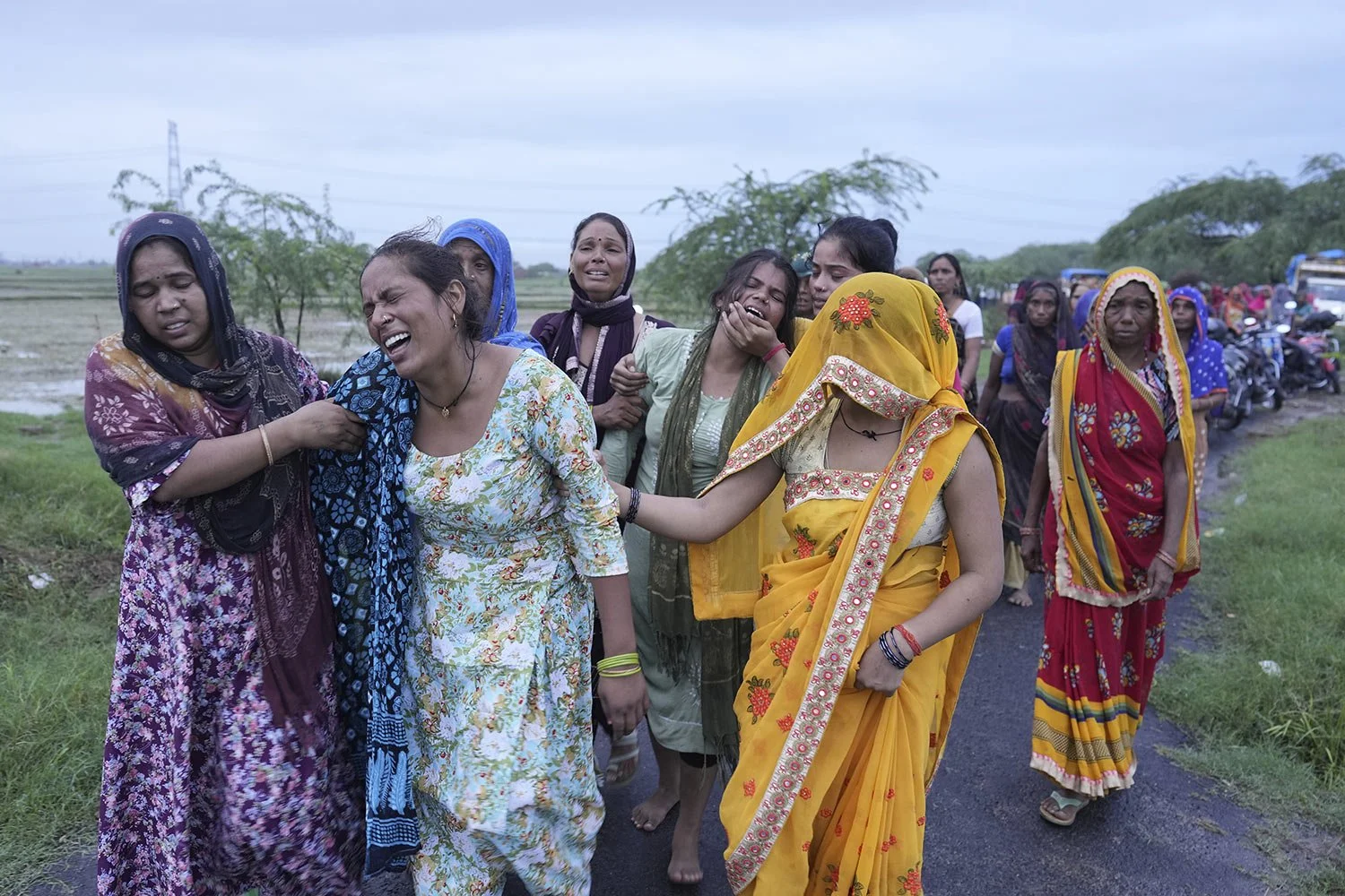  Bharti Kumari, second left, and Sonam, centre in green, weep as the body of their mother, Savitri Devi, 50, who died from a stampede at a religious festival, is carried for cremation in Ramnagar, in the northern Indian state of Uttar Pradesh, Wednes