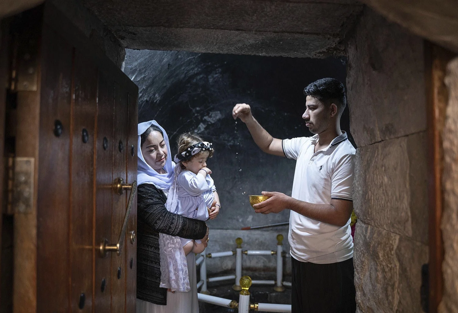  A child is baptized in Lalish, the Yazidi's most holy temple, in the Shekhan district of the Kurdistan region of Iraq, Monday, June 24, 2024. (AP Photo/Julia Zimmermann) 