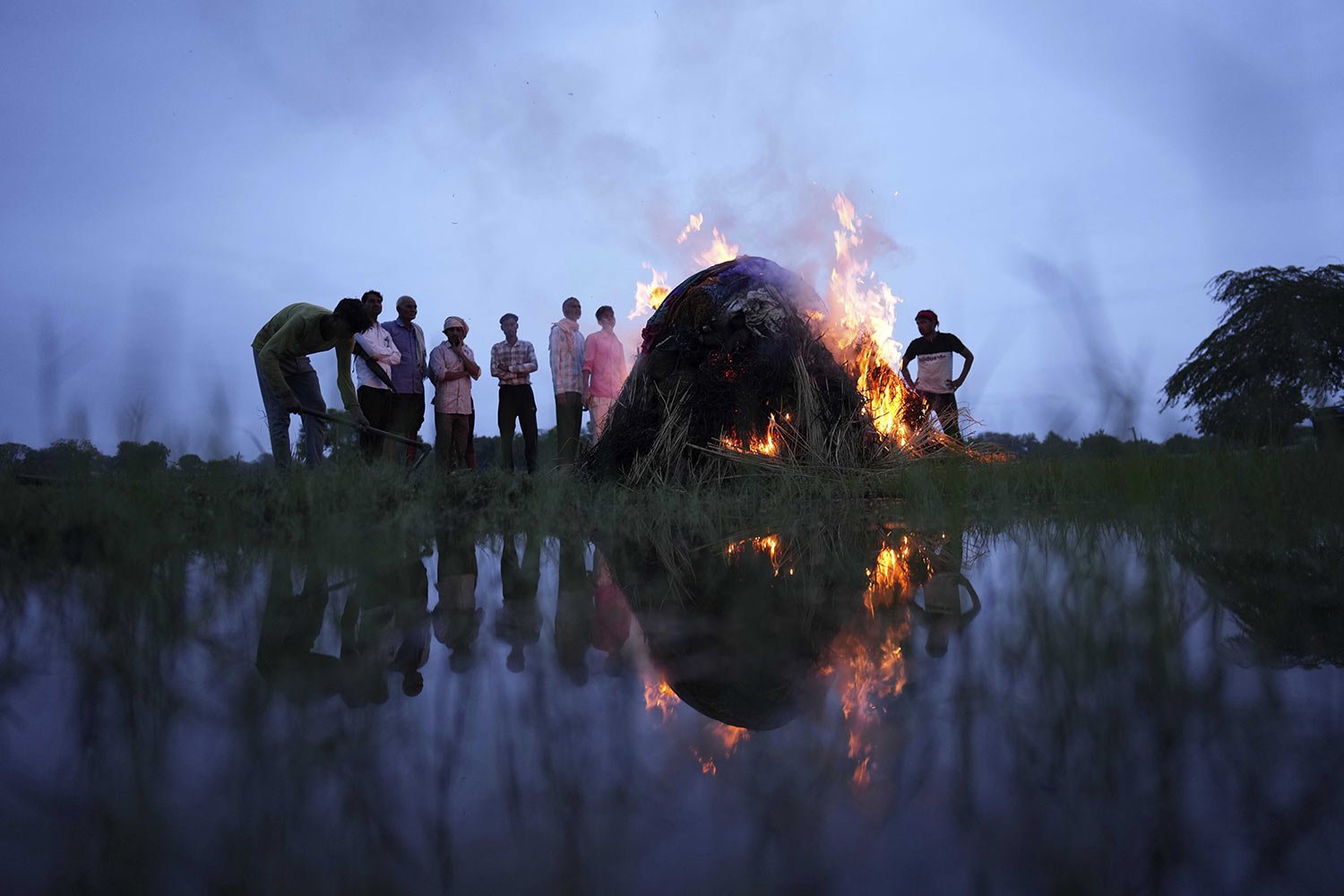  Flames rise from the cremation pyre of Savitri Devi, 50, who died from a stampede which occurred at a religious festival, in Ramnagar, in the northern Indian state of Uttar Pradesh, Wednesday, July 3, 2024. (AP Photo/Rajesh Kumar Singh) 