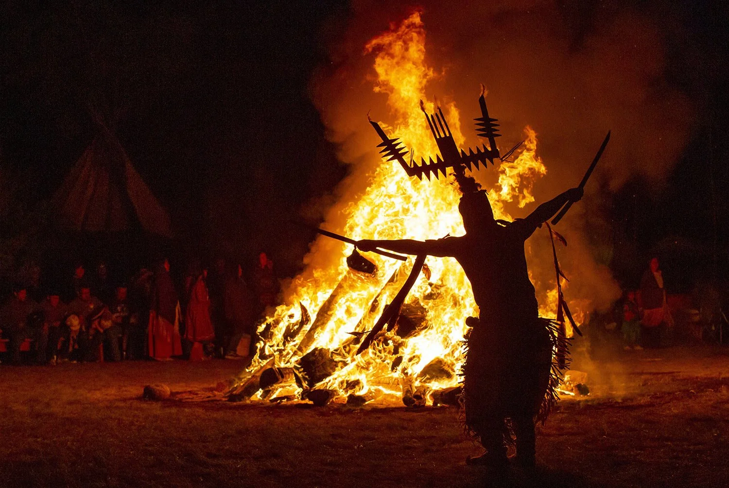  An Apache Crown Dancer whirls around the bonfire during a coming-of-age blessing ceremony for two young tribe women in Mescalero, New Mexico, Saturday, July 13, 2024. (AP Photo/Andres Leighton) 