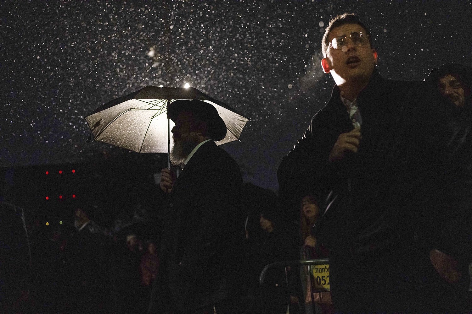  Attendants listen under the rain as a rabbi delivers an eulogy during a ceremony prior to the funeral of Israeli-Moldovan rabbi Zvi Kogan in Kfar Chabad, Israel, Monday Nov. 25, 2024. Kogan, 28, an ultra-Orthodox rabbi, was killed last week in Dubai