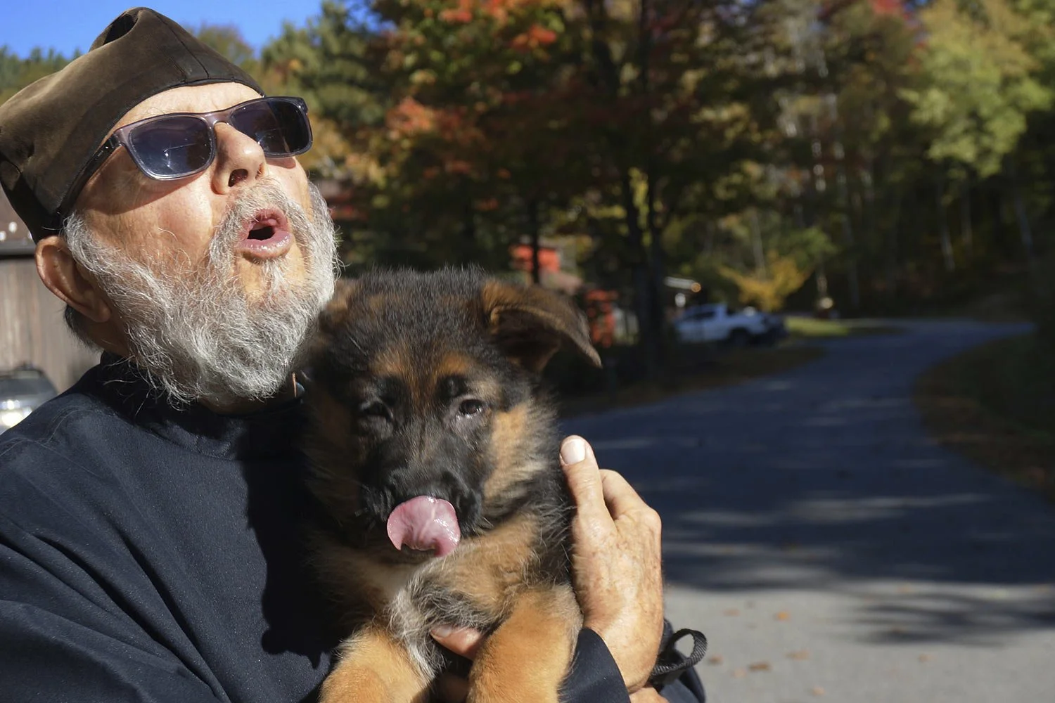  Brother Luke, an Orthodox Christian monk, holds his 10-week-old German shepherd Pyrena on the grounds of the New Skete monastery, where he directs the dog breeding program that has provided both financial and spiritual support to the community for d