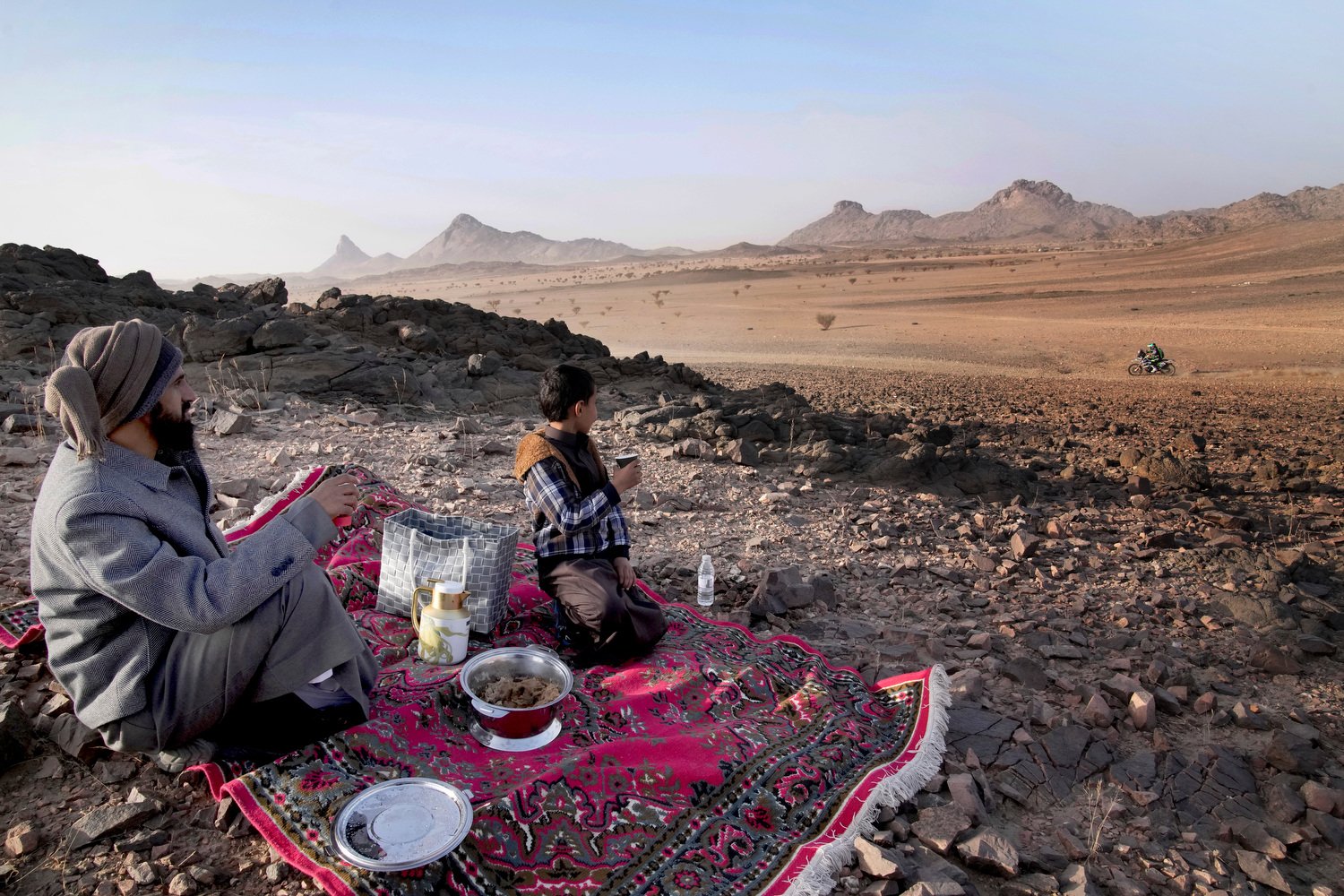 A family watches racers during the prologue of the Dakar Rally in Bisha, Saudi Arabia, Jan. 3, 2025. (AP Photo/Christophe Ena)