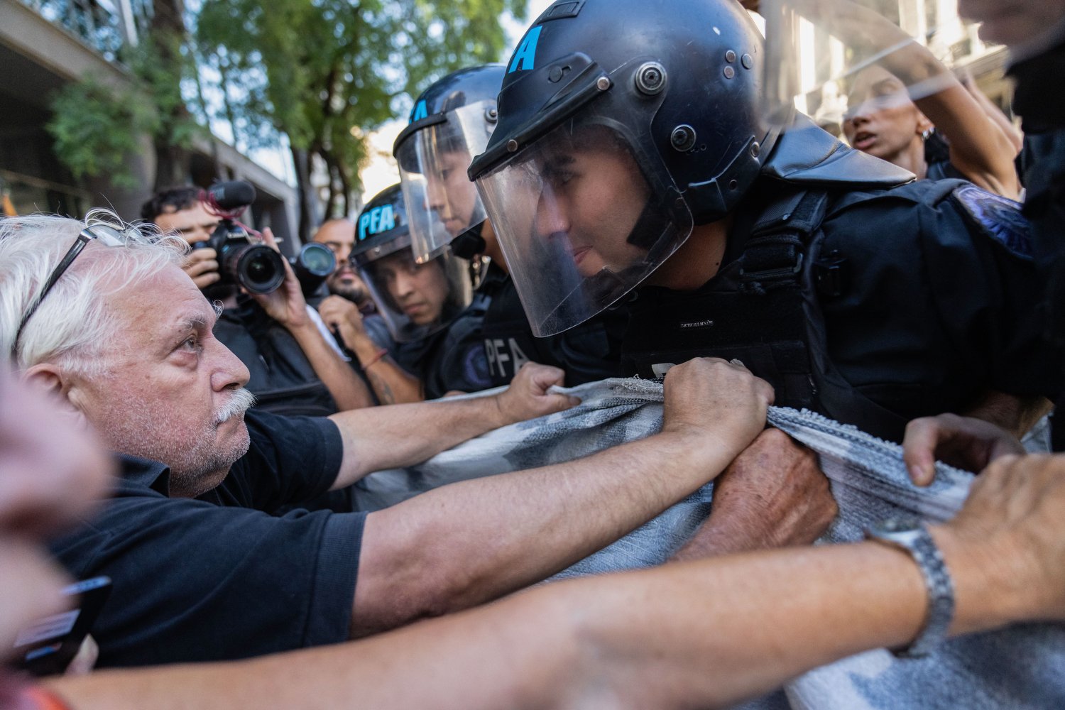 Riot police and retirees vie for space on a street during a protest for better pensions in Buenos Aires, Argentina, Feb. 19, 2025. (AP Photo/Rodrigo Abd)