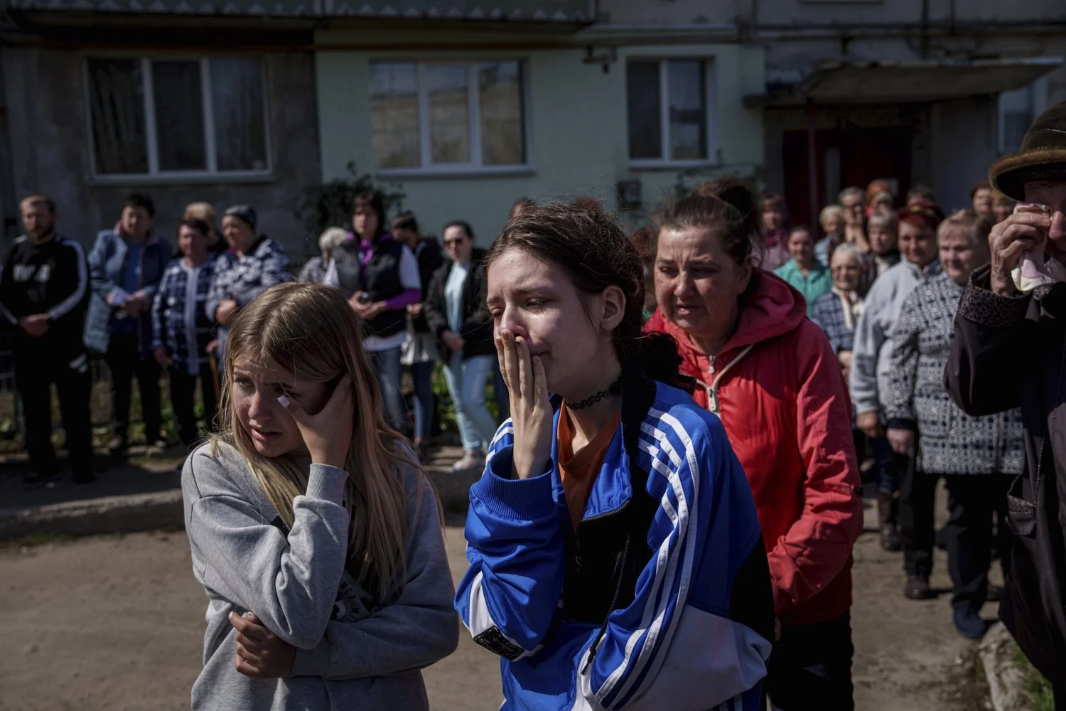 Children cry during a farewell ceremony for Maksym Martynenko, 11, Natalia Martynenko, 49, and Mykola Martynenko, 41, killed in a deadly Palm Sunday Russian attack on Sumy on April 13, in Stare Selo village near Sumy, Ukraine, Wednesday, April 16, 2