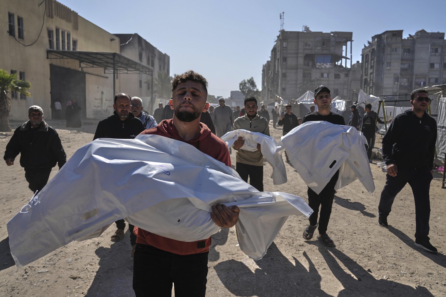 Mourners carry white sacks cover the bodies of members of the Abu Al-Rous family, killed when an Israeli airstrike struck their displacement tent overnight, during their funeral in Khan Younis, southern Gaza Strip, Thursday, April 17, 2025. (AP Phot