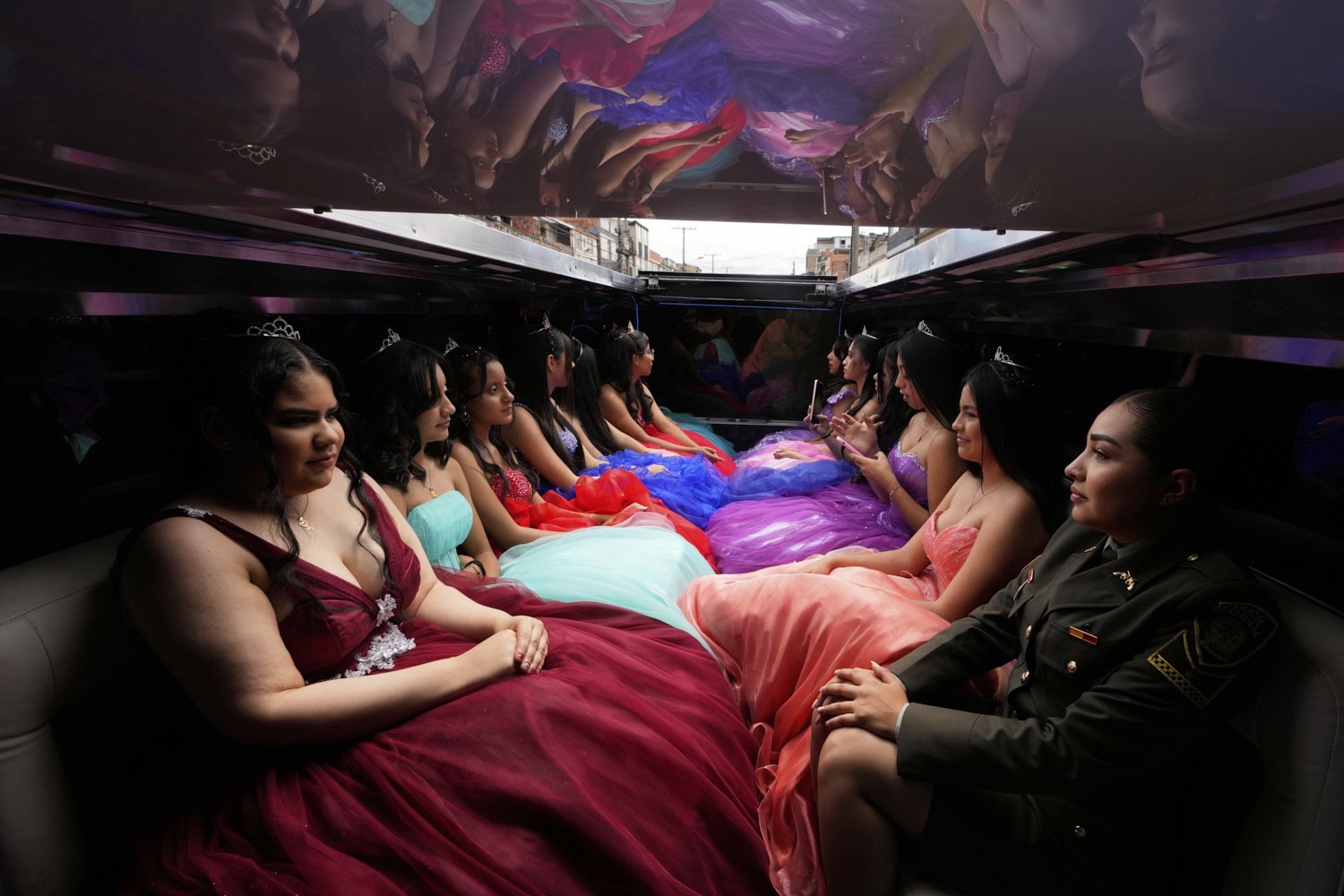 Quinceañeras ride in limousine as part of their celebration, in Bogota, Colombia, Friday, May 2, 2025. The Sueños Hechos Foundation, led by a former police officer, is hosting a quinceañera celebration on Friday for 24 disadvantaged teen girls. (AP