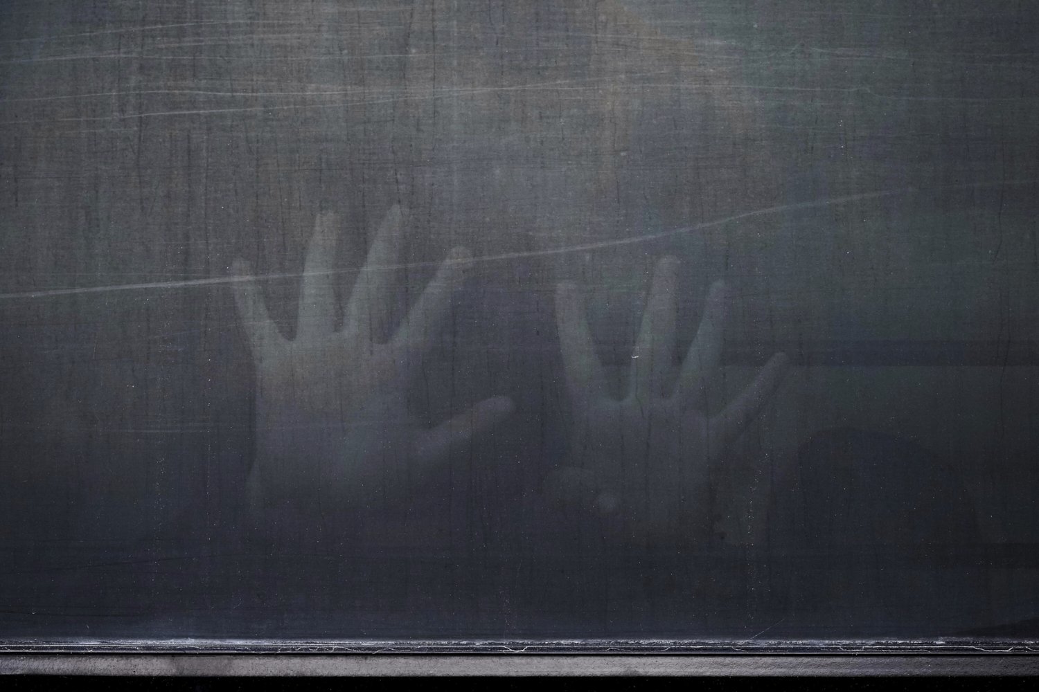 A woman from Peru signals through the barred and tinted windows of a bus after she was detained following an appearance at immigration court, Monday, June 23, 2025, in San Antonio. (AP Photo/Eric Gay)