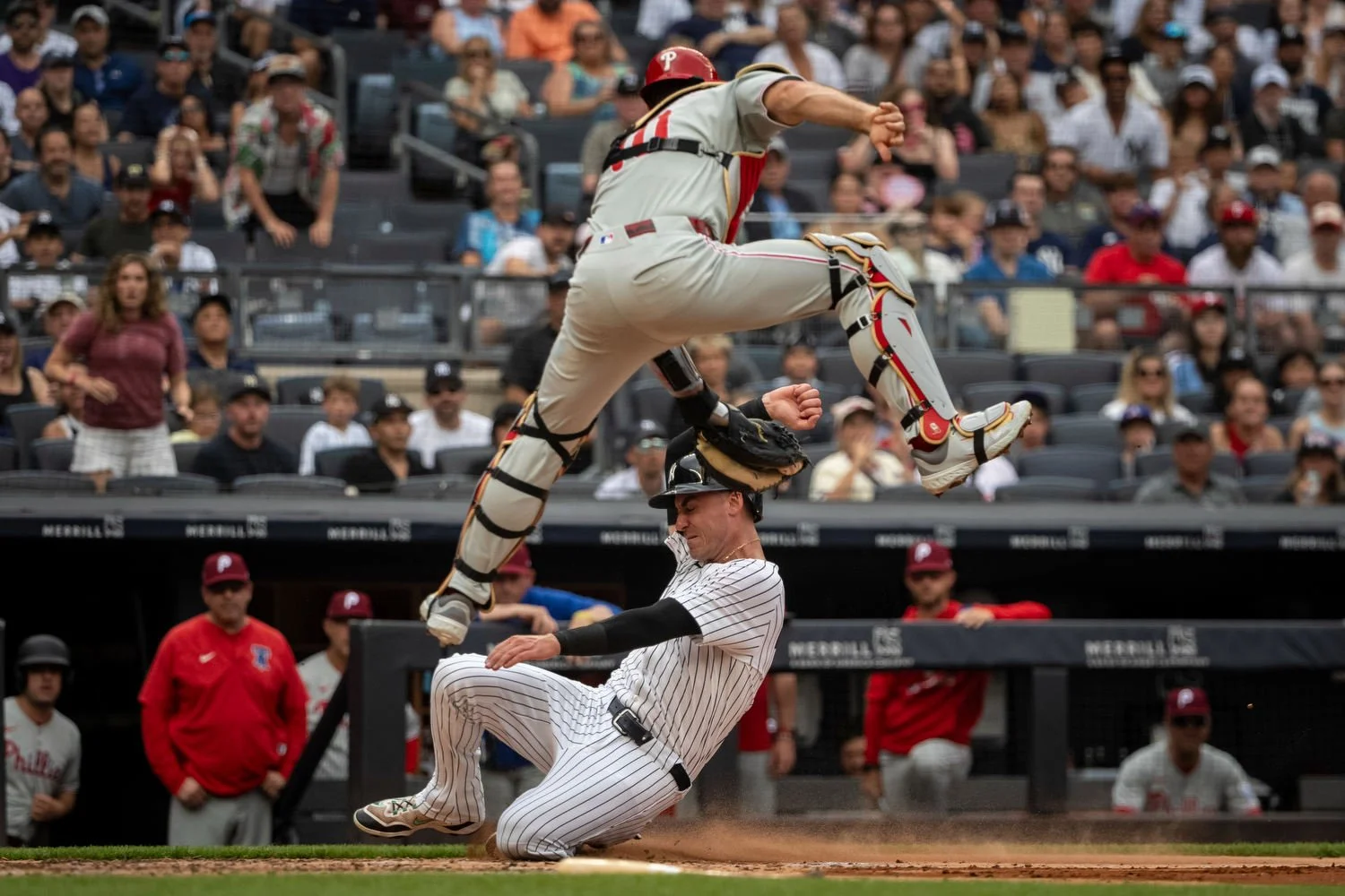 New York Yankees baseball player Cody Bellinger is tagged out at home plate by Philadelphia Phillies catcher J.T. Realmuto, top, in the third inning, in New York, July 27, 2025. (AP Photo/Angelina Katsanis)