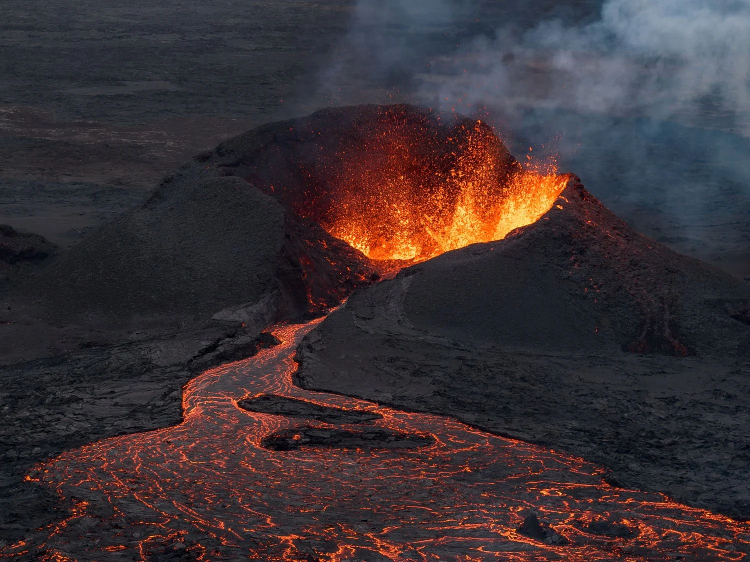 Lava flows at the base of the crater which is still active after a volcanic eruption on the Reykjanes Peninsula, north of Grindavik, Iceland, July 23, 2025. (AP Photo/Marco di Marco)