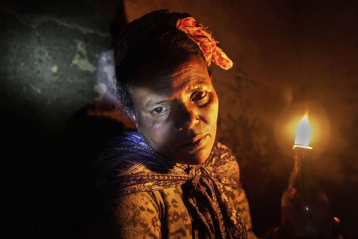 Fanuse Adete, 38 years-old, holds up a candle she uses to light her home at night in the Menabichu district on the outskirts of Addis Ababa, Ethiopia, Saturday, Sept. 6, 2025. (AP Photo/Brian Inganga)